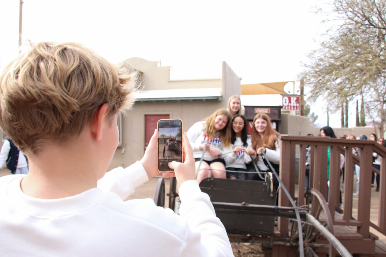 A student takes a group photo of his friends.