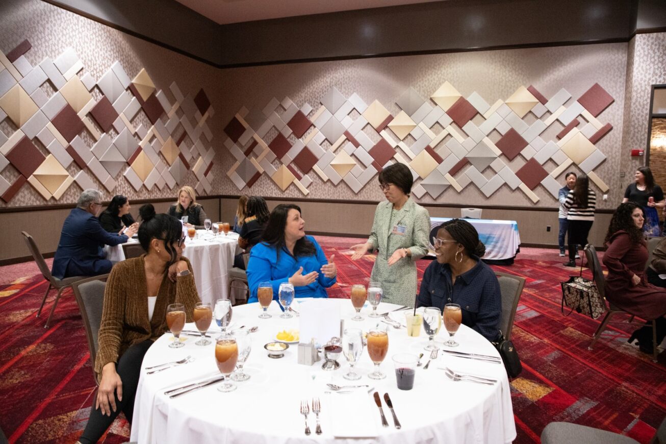 F六合开奖记录 women sit around a table talking at the appreciation dinner