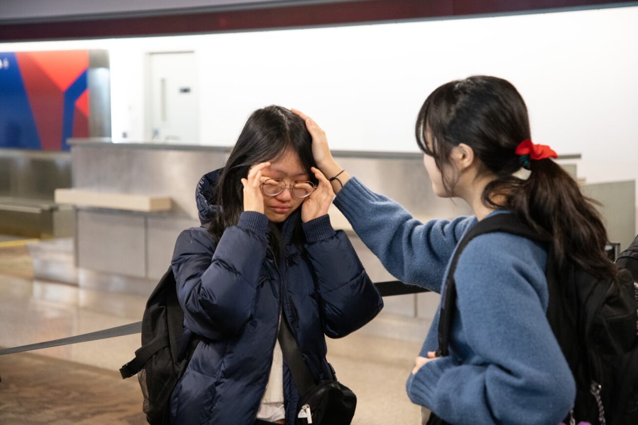A Korean student cries while her friend comforts her