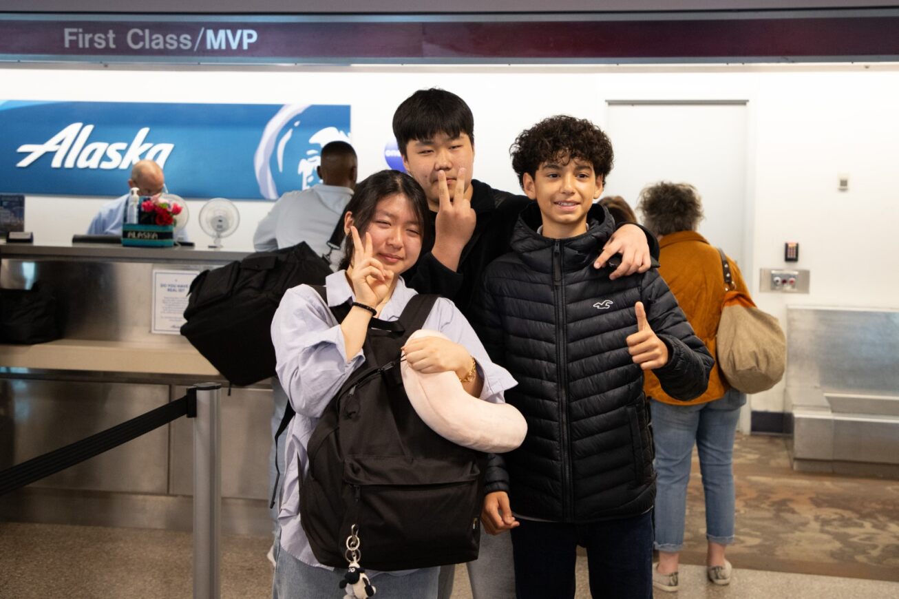 Two Korean students and their host brother pose for a picture