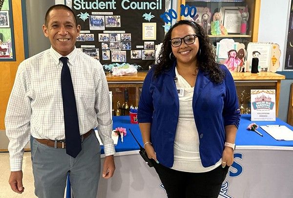 Dr. Trujillo and a Miles K-8 teacher smile inside the school